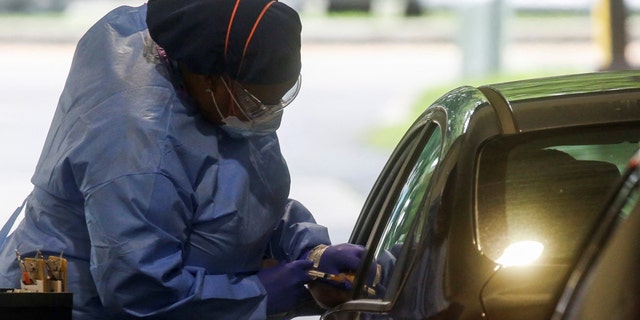 A staff member of the Westchester Medical Center applies a monkeypox vaccine to a person in a drive-through monkeypox vaccination point at the Westchester Medical Center in Valhalla, New York, U.S., July 28, 2022. 